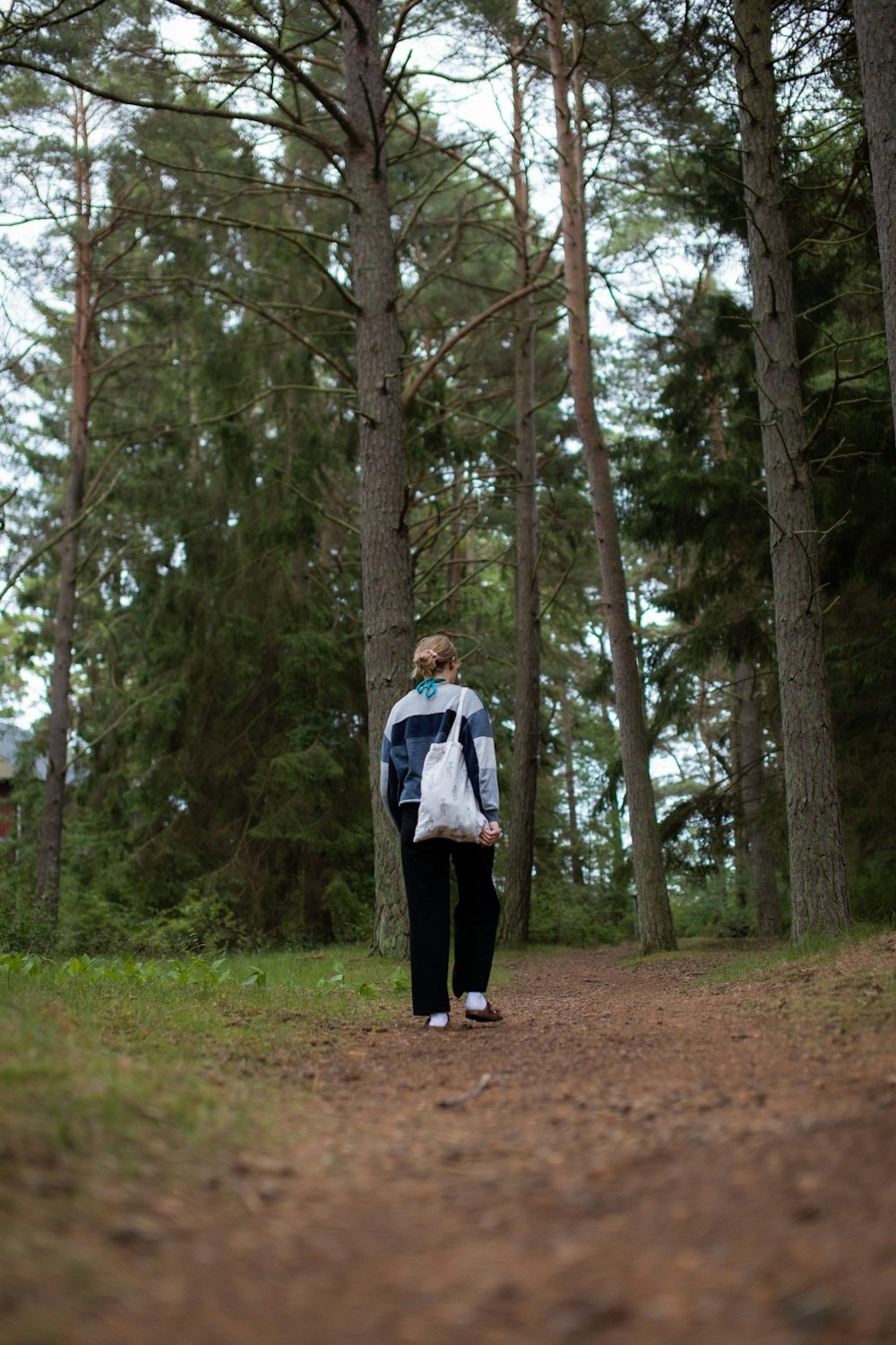 a woman walking down a path in the woods