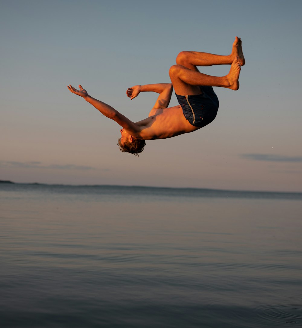 a man is doing a flip in the water