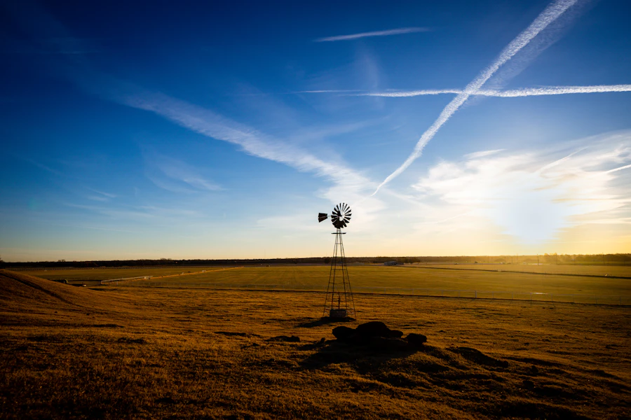 A windmill on the prairie under a bright sky