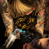a woman getting a tattoo on her arm