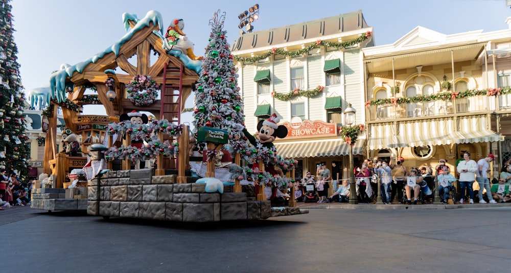 a mickey mouse float in a parade in front of a building