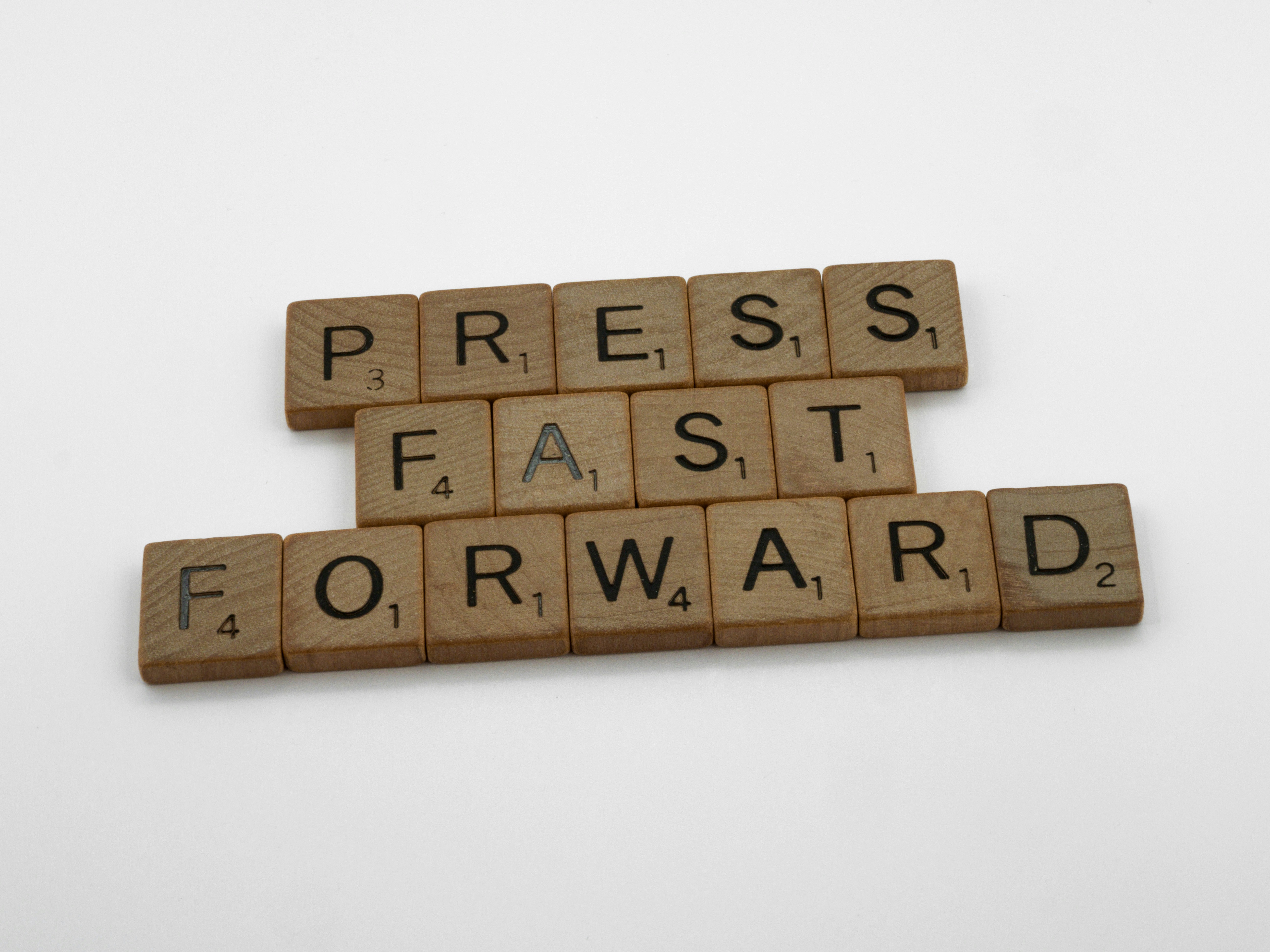 scrabble, scrabble pieces, lettering, letters, wood, scrabble tiles, white background, words, quote, letters, type, typography, design, layout, focus, bokeh, blur, photography, images, image, press fast forward, speed up, let it go, impatient, move on, no time to waste, progress, hurry up, get a move on,