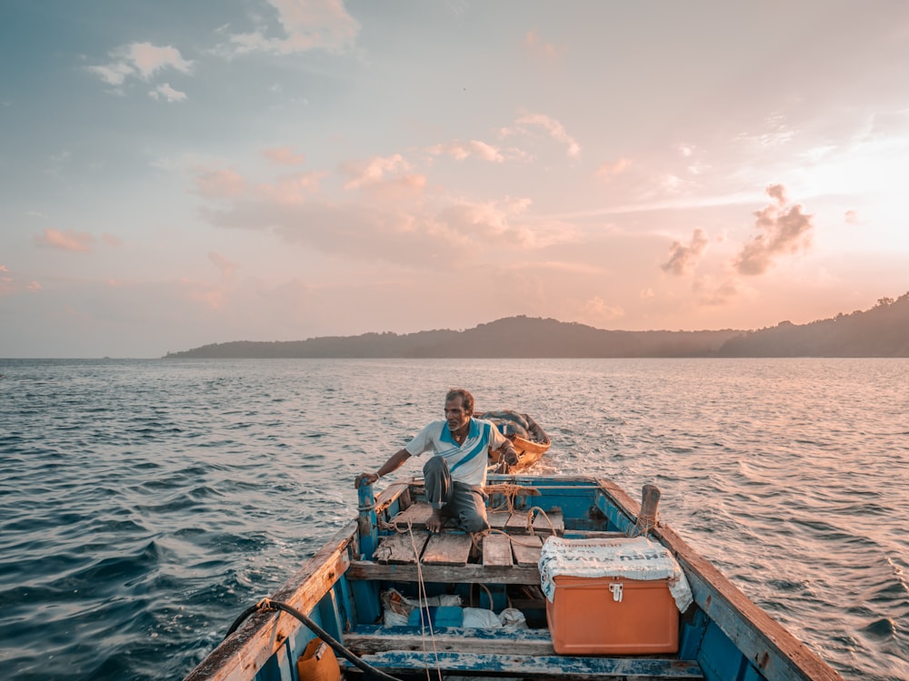 a man sitting on a boat in the middle of the ocean