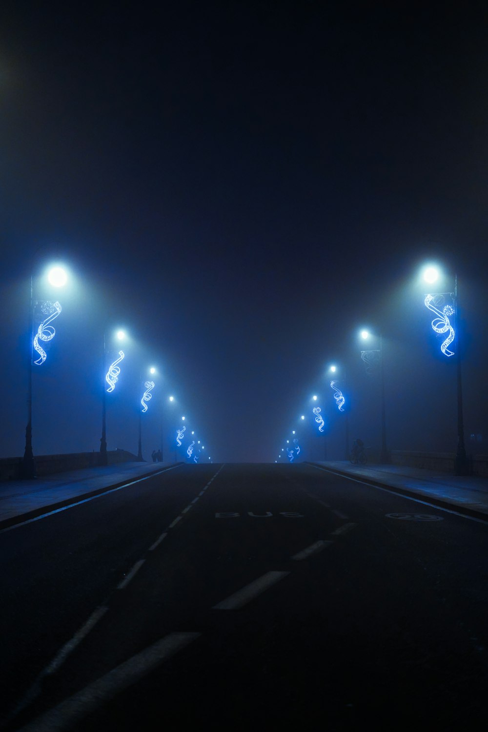 a foggy street at night with street lights