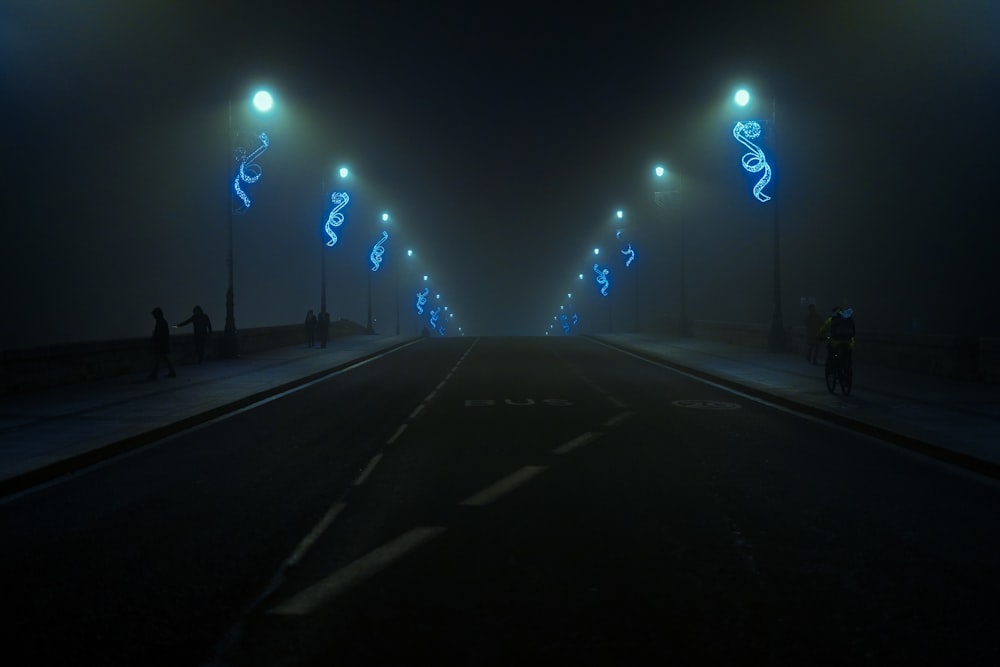 a dark street at night with street lights lit up