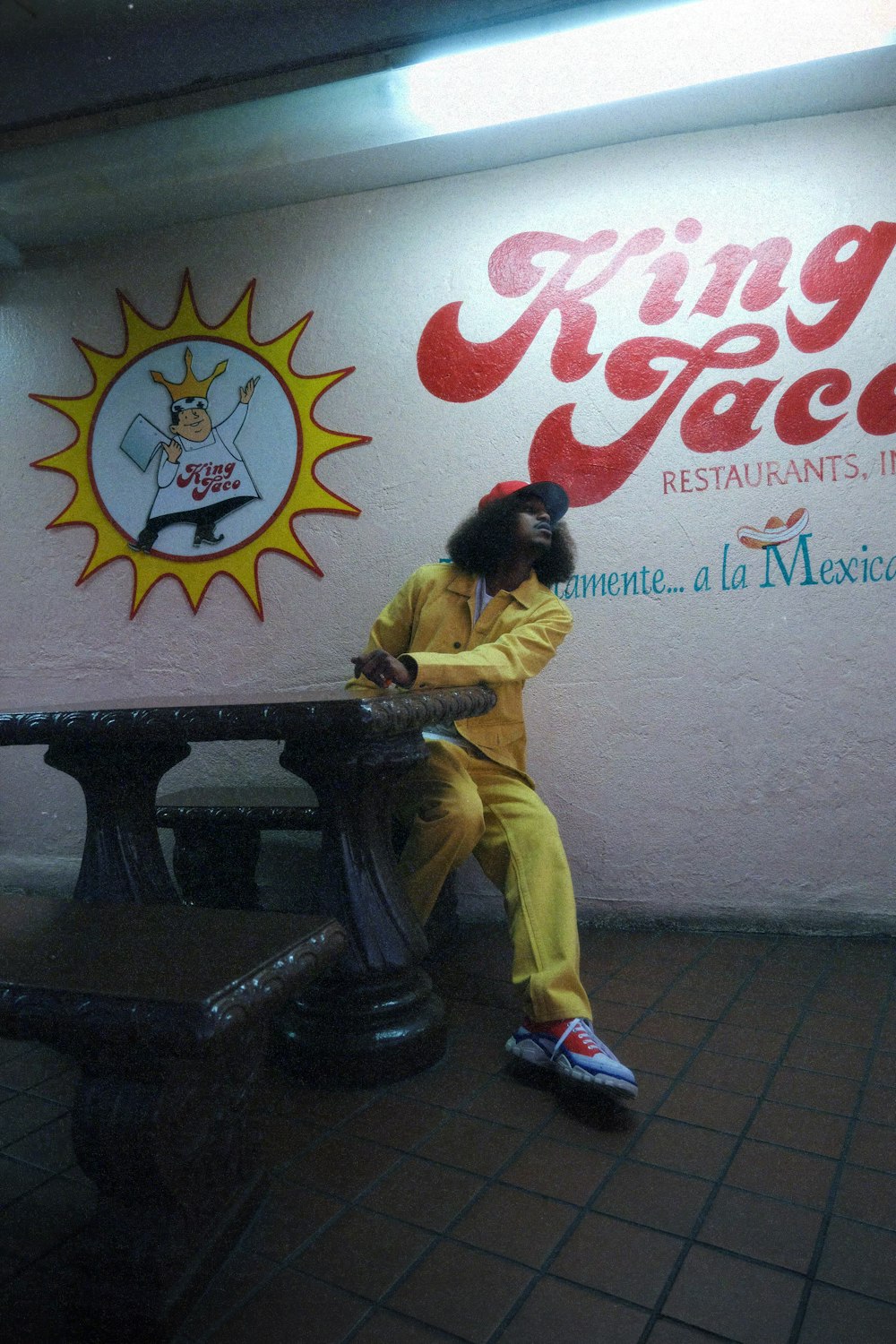 a man sitting on a bench in front of a restaurant