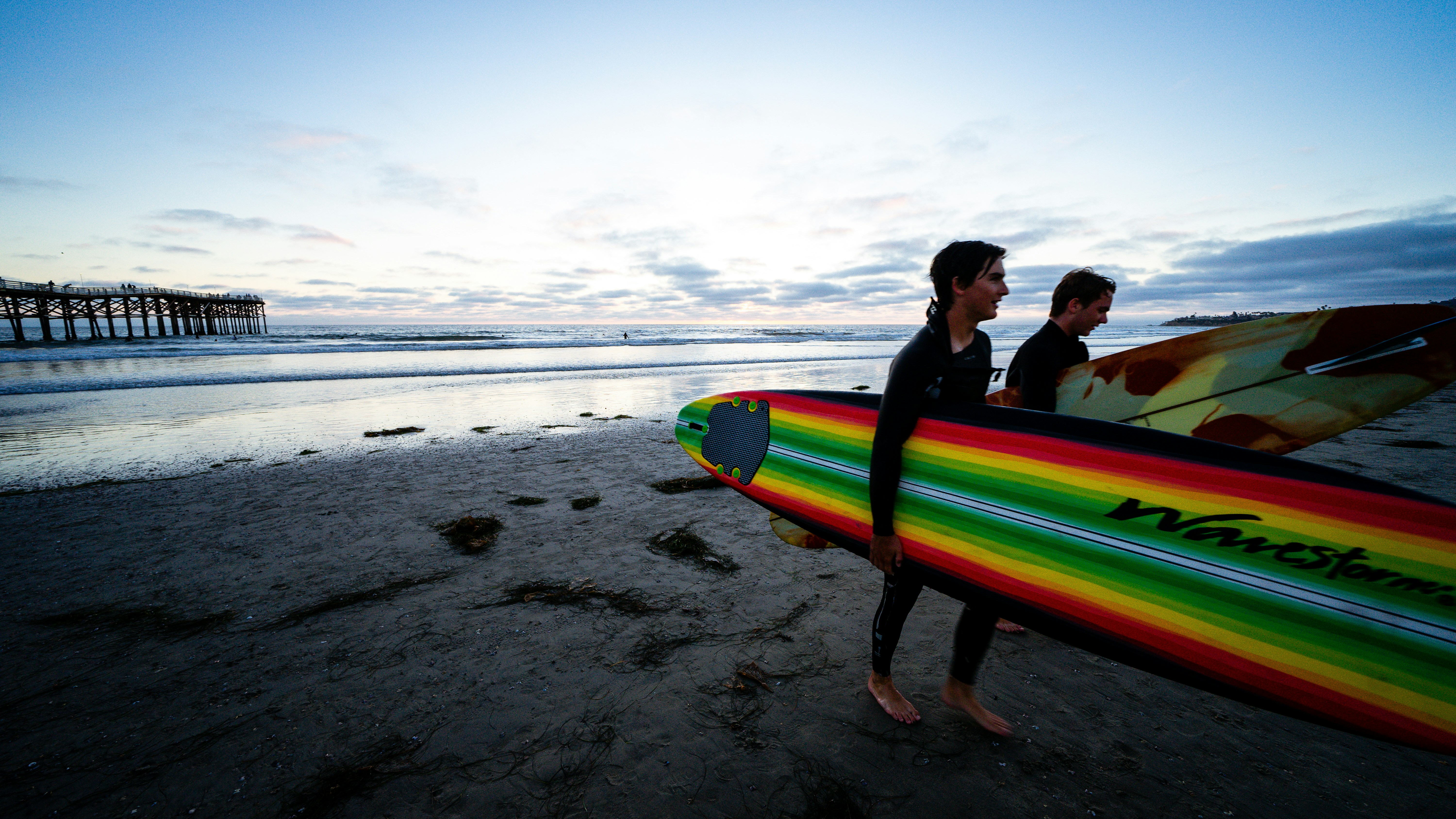 a couple of people holding surfboards on a beach