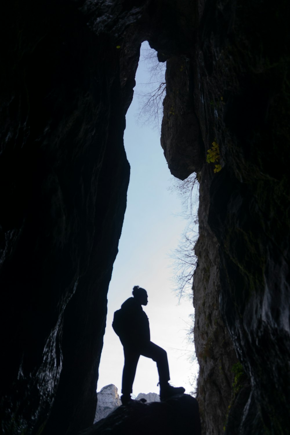 a man standing in a cave looking up at the sky
