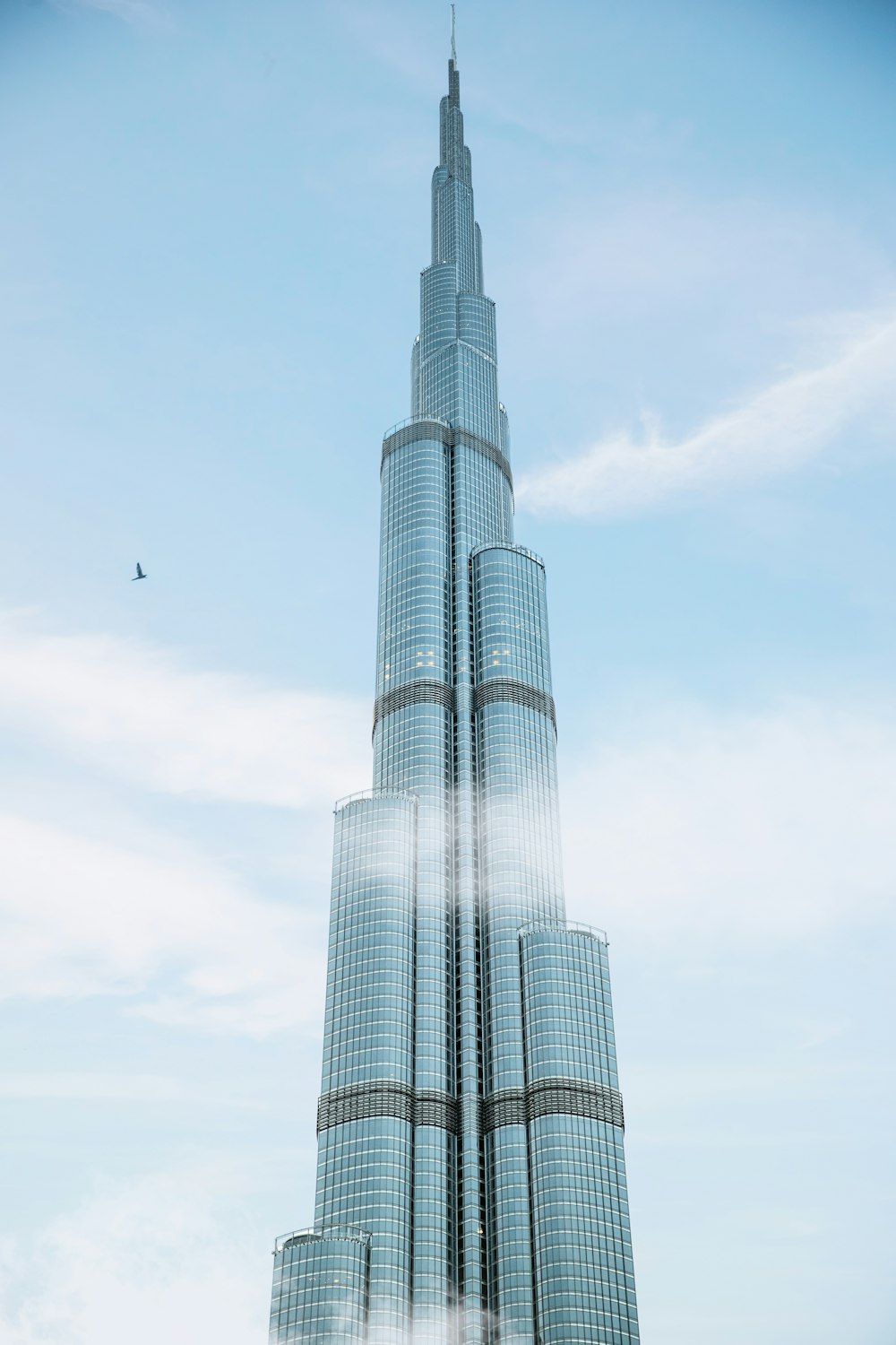 a very tall building with a bird flying by