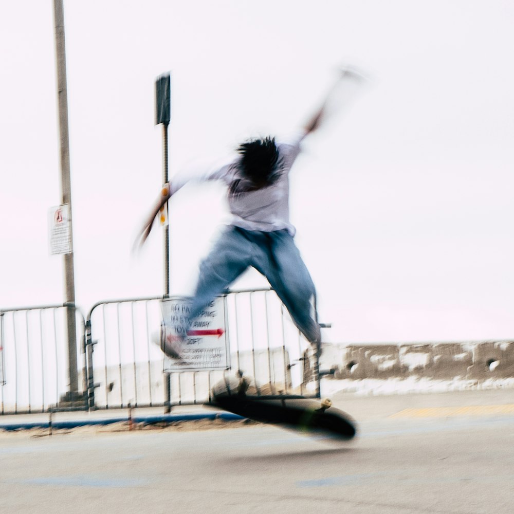 Un hombre montando una patineta al costado de una carretera