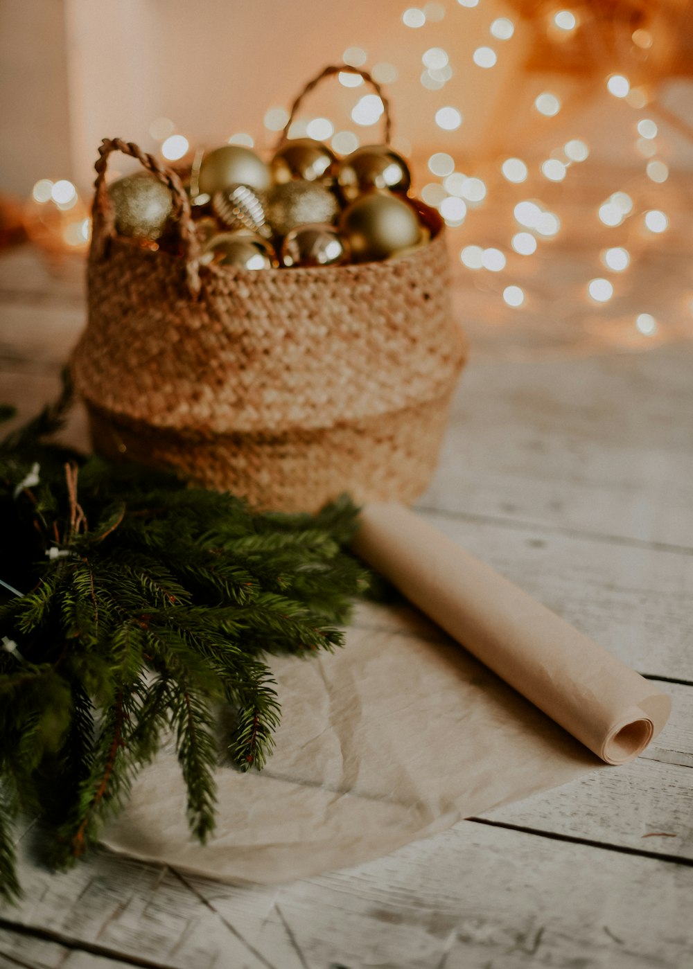 Una cesta llena de adornos navideños encima de una mesa de madera