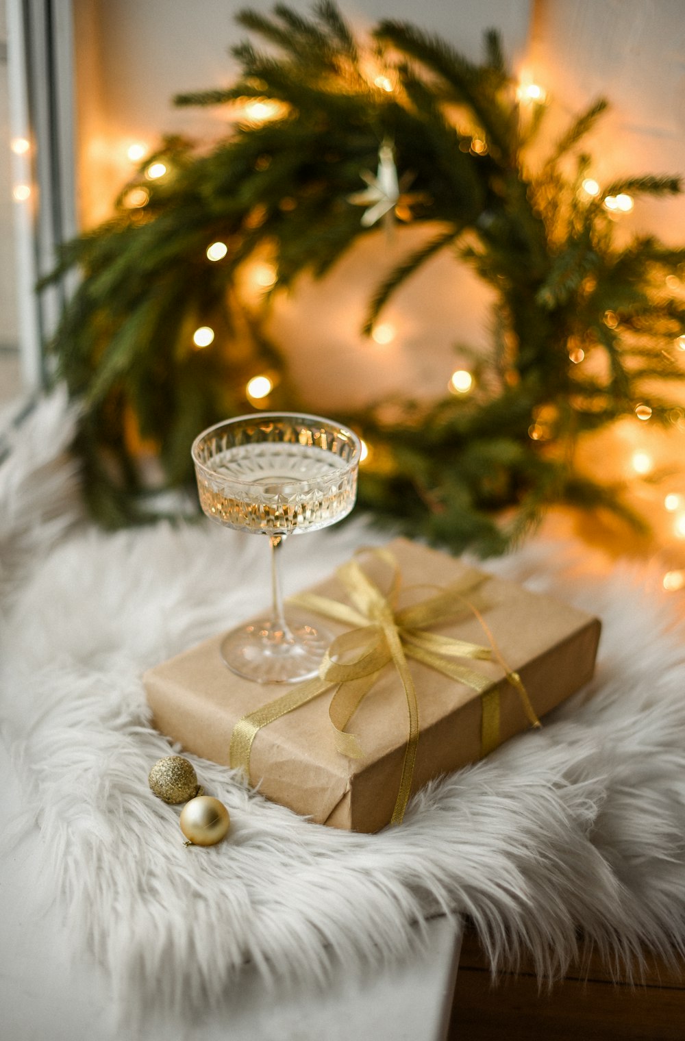 a gift wrapped in brown paper and a wine glass