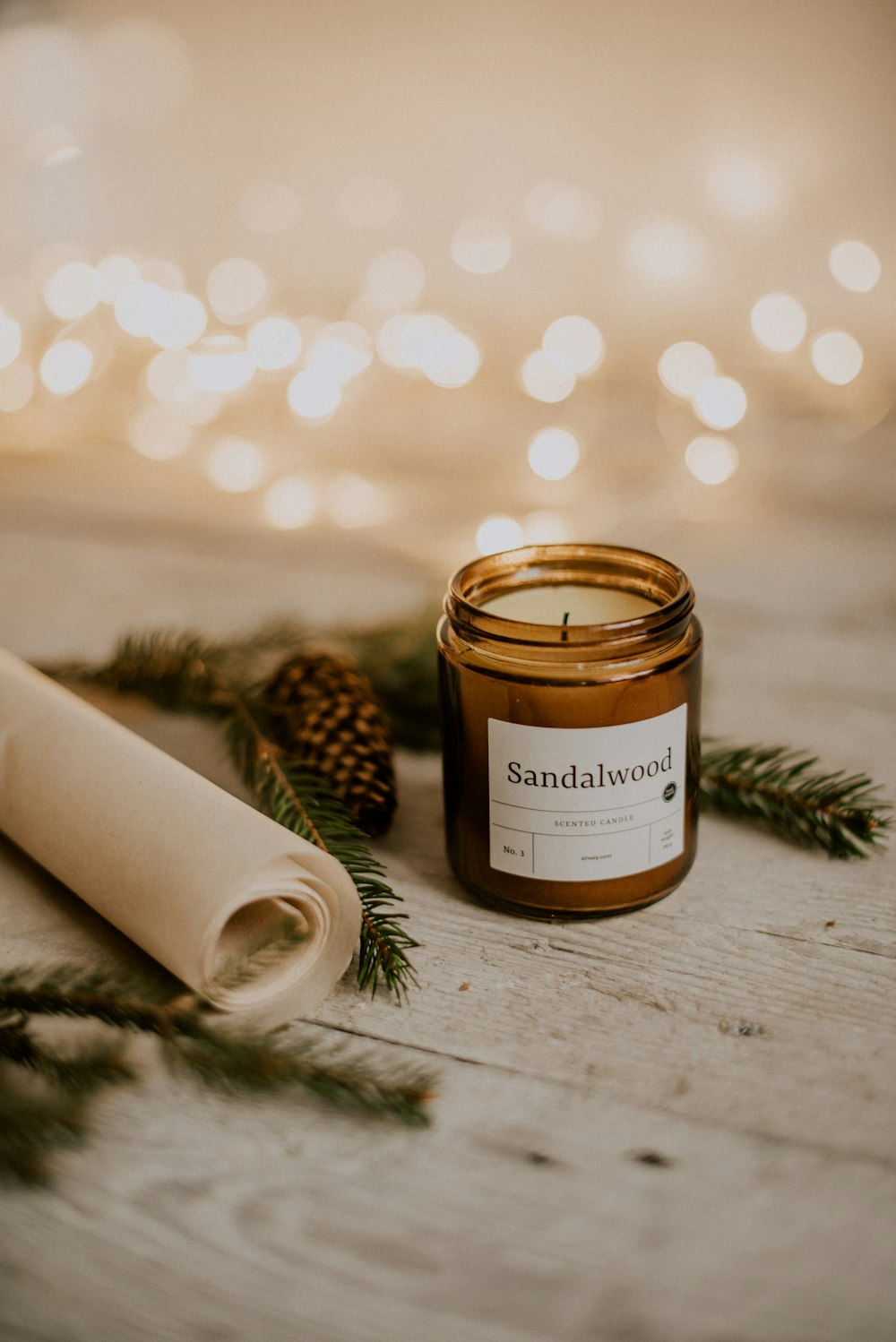 a candle sitting on a table next to a roll of paper