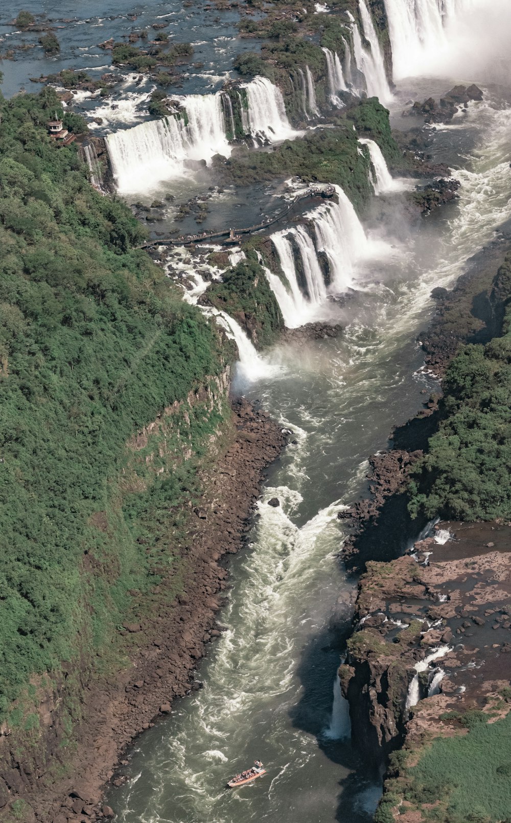 ein großer Wasserfall mit einem Boot in der Mitte