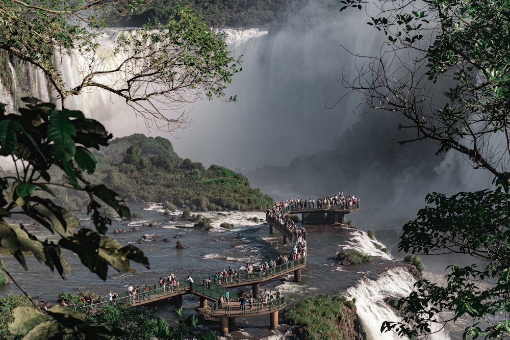 a group of people standing on a bridge over a river