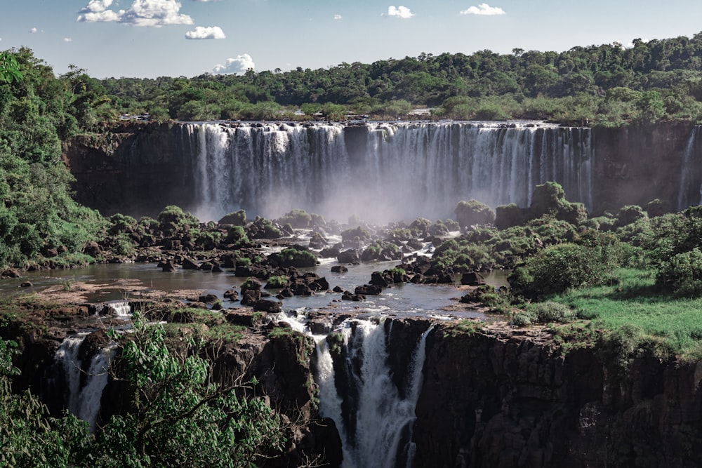 a large waterfall in the middle of a forest