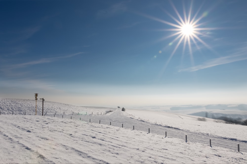 the sun shines brightly over a snowy landscape