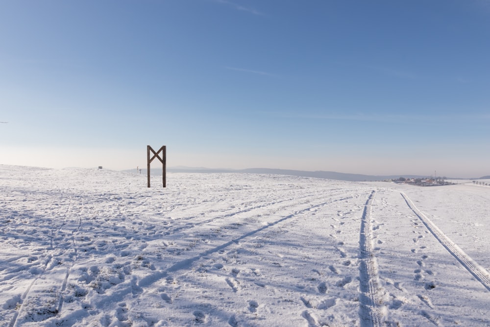 a snow covered field with tracks in the snow