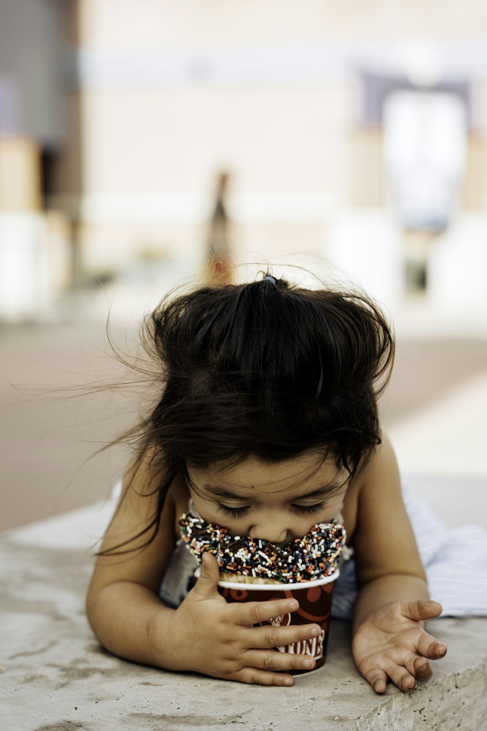 Una niña con una rosquilla en la boca