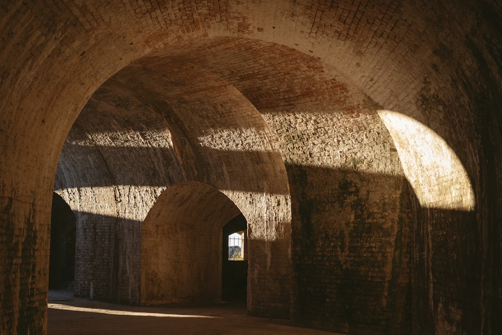 a stone tunnel with sunlight coming through it