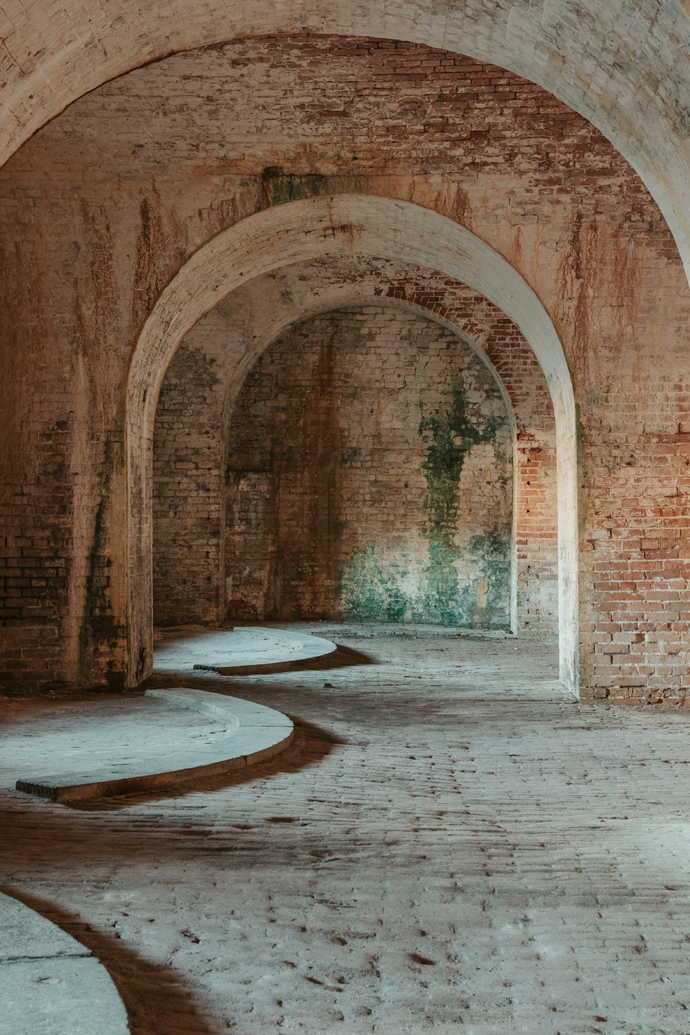 a long brick tunnel with a clock on the wall