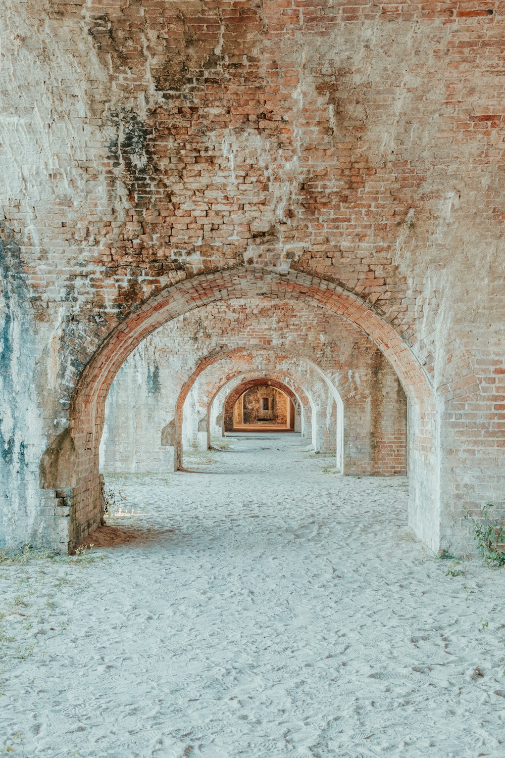 un tunnel en briques avec un banc au milieu