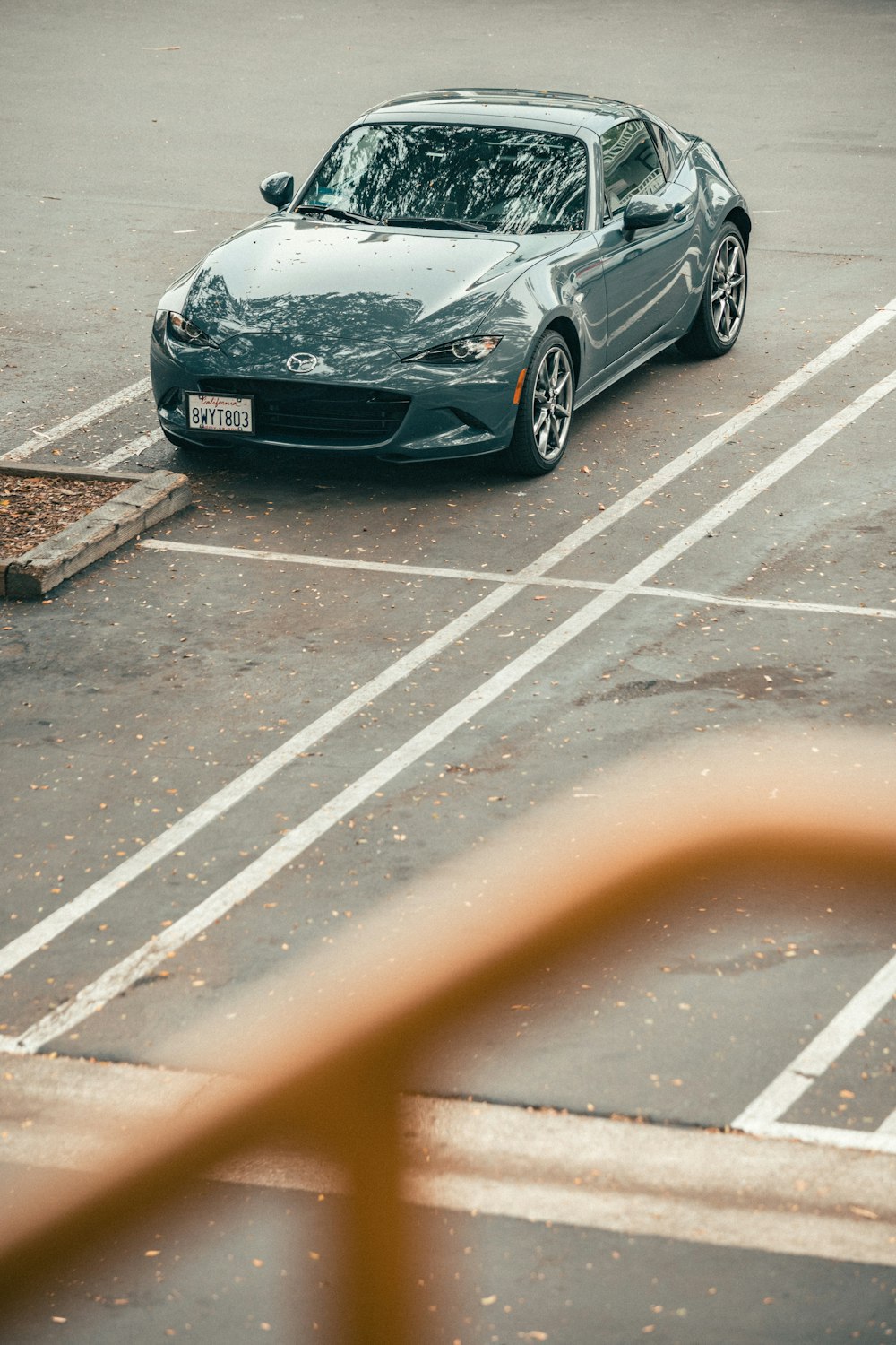 Un auto deportivo gris estacionado en un estacionamiento