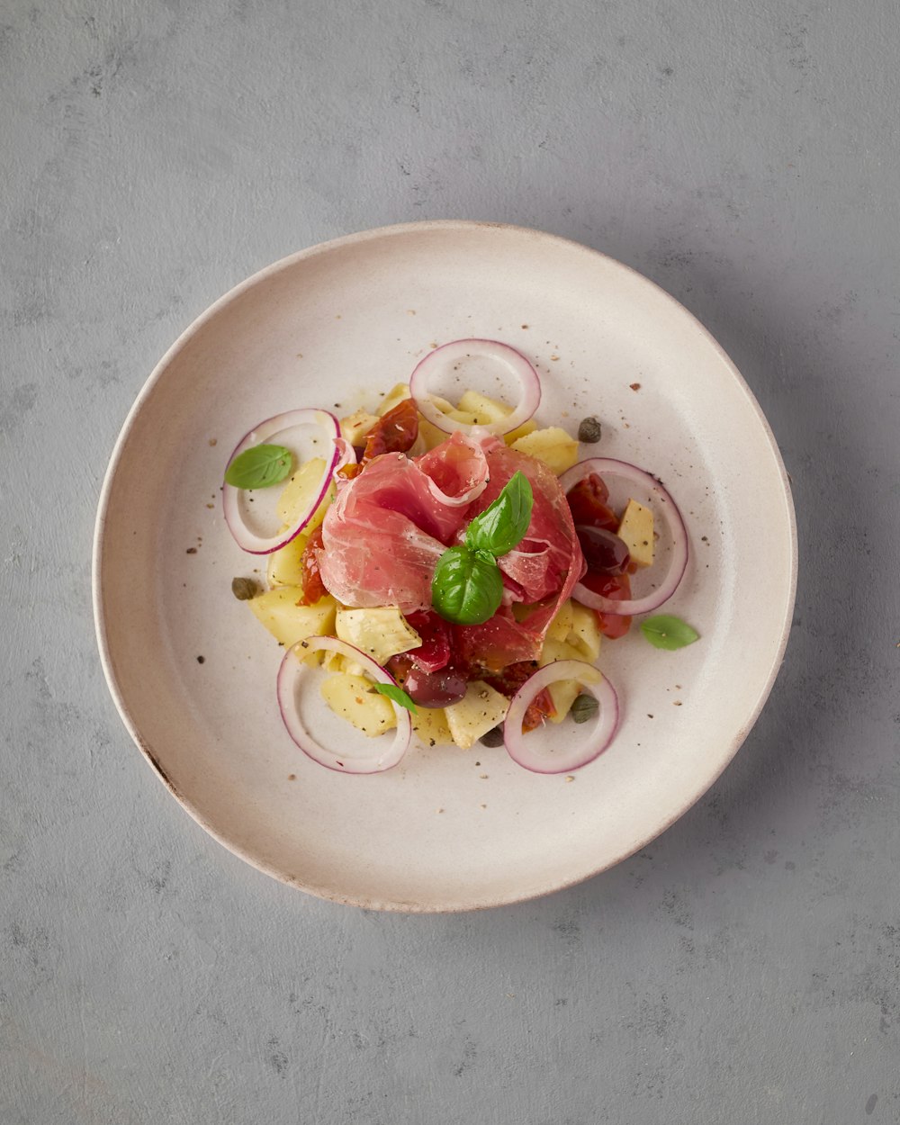 une assiette blanche garnie de viande et de légumes