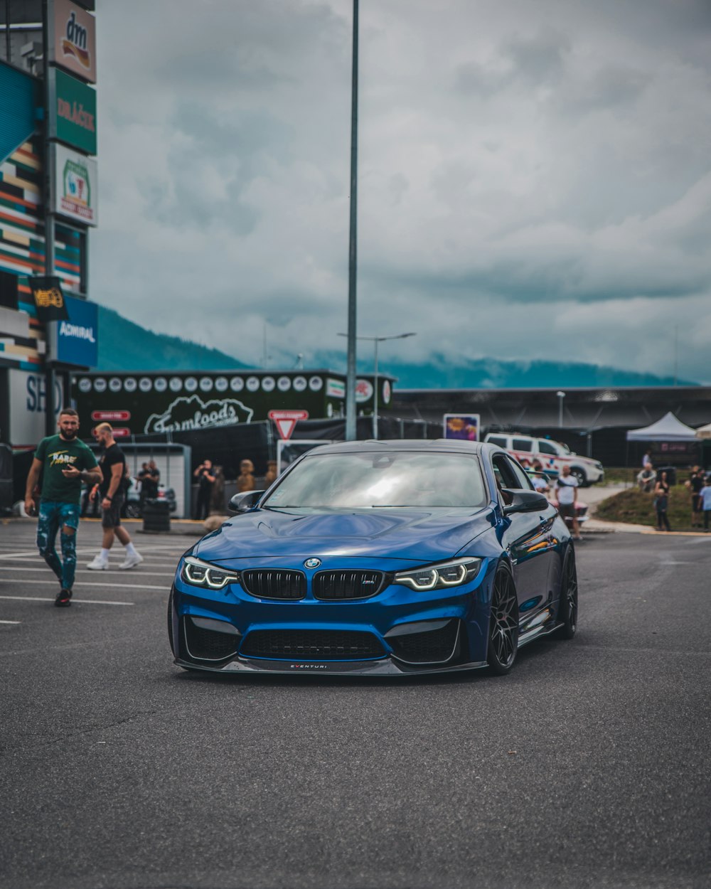 a blue bmw car parked in a parking lot