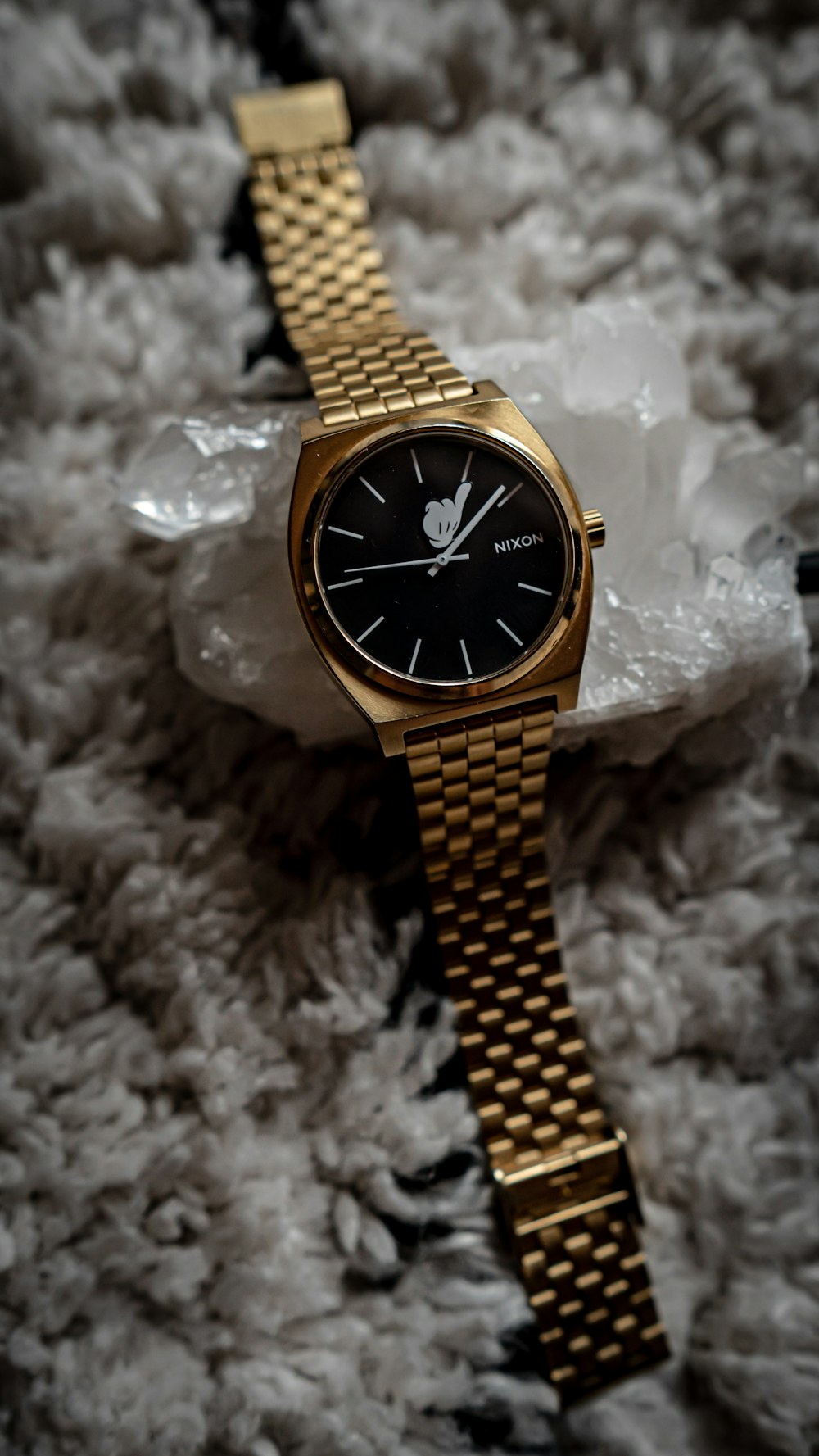 a gold watch sitting on top of a pile of white fur