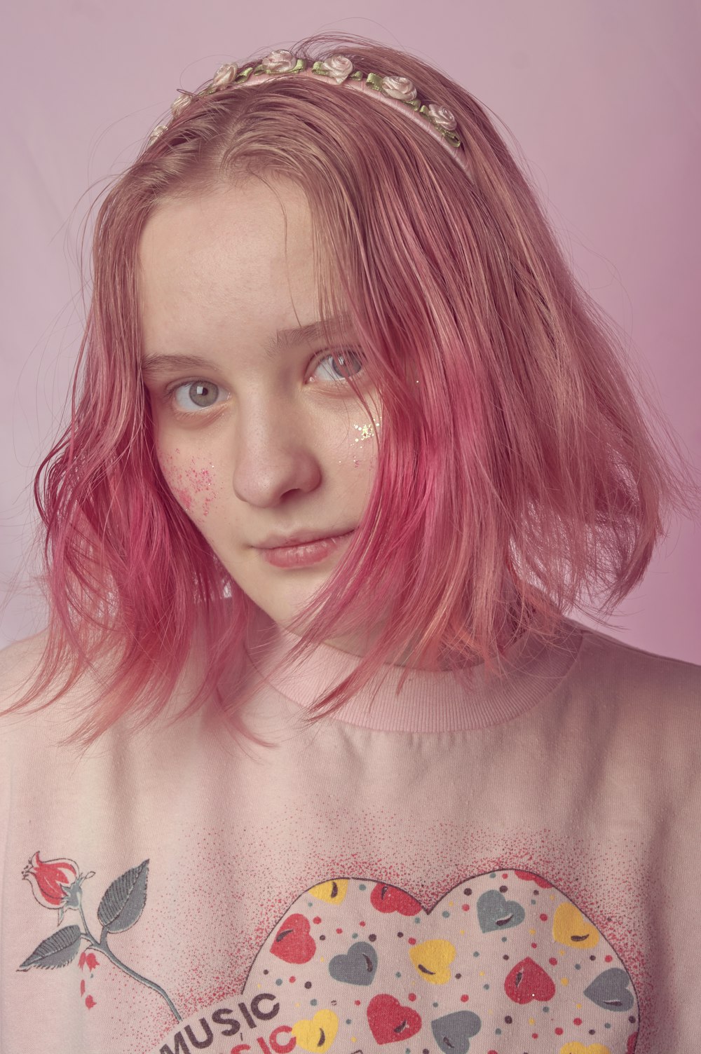 a girl with pink hair wearing a t - shirt with hearts on it