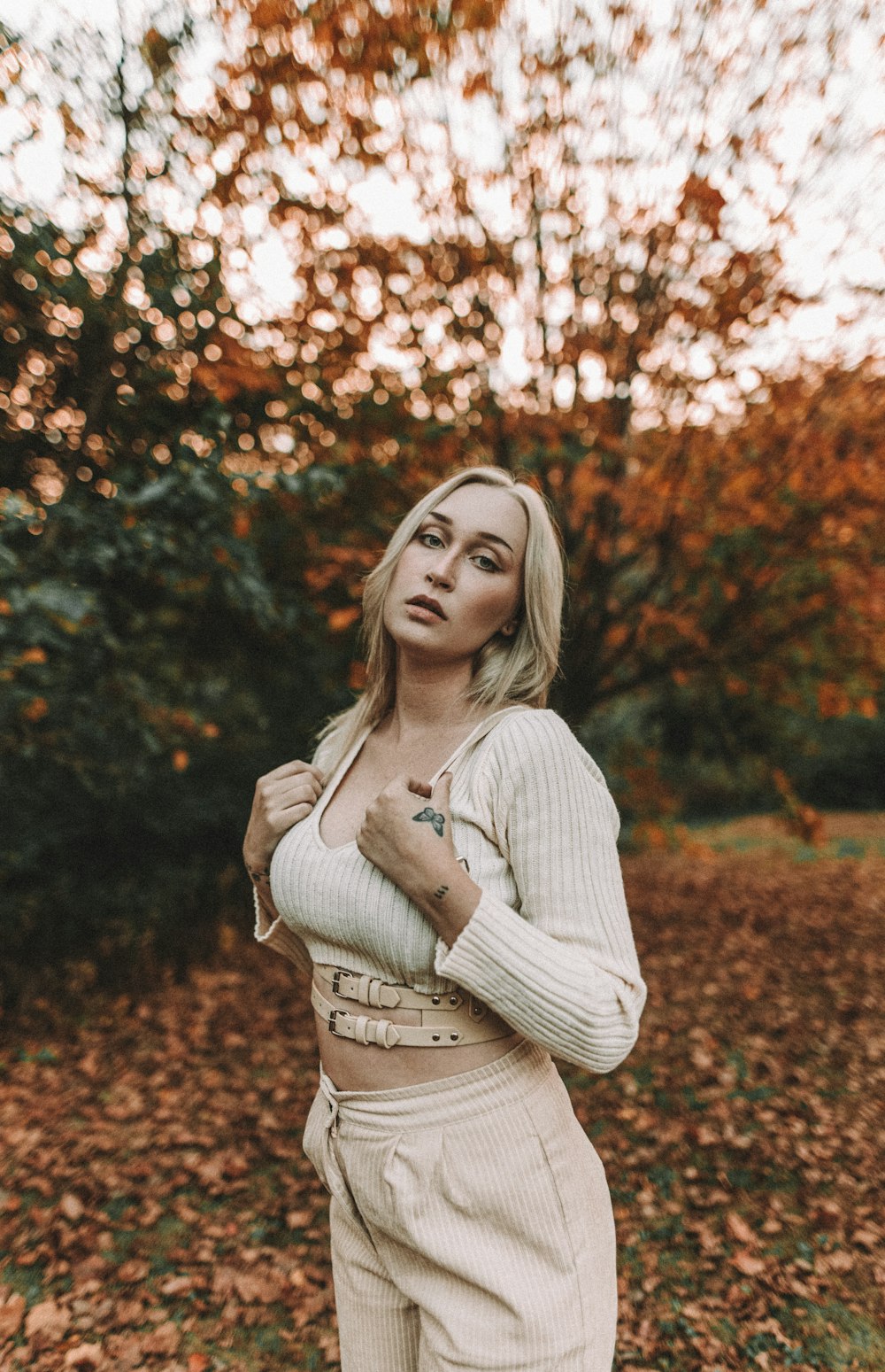 a woman standing in a field of leaves