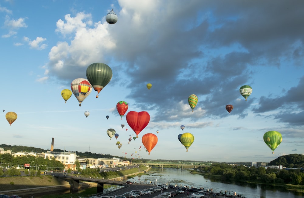a bunch of hot air balloons flying over a river