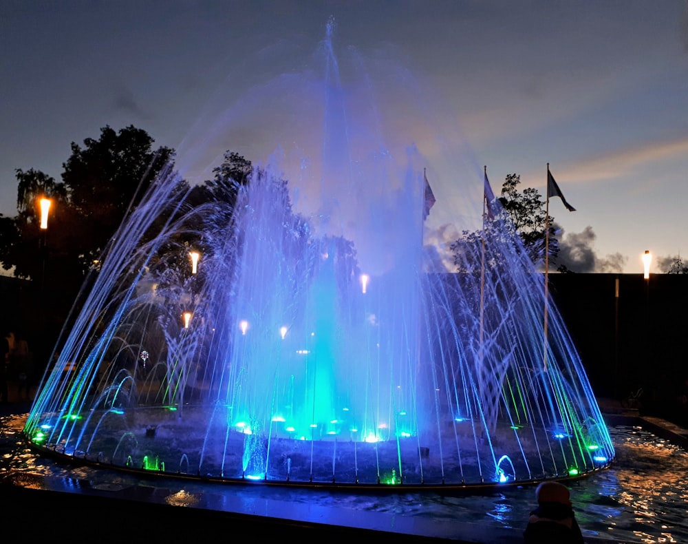 a large water fountain lit up at night