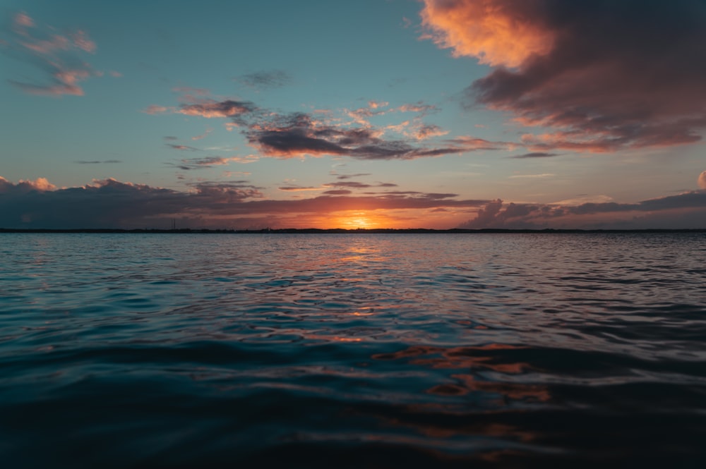 the sun is setting over a body of water