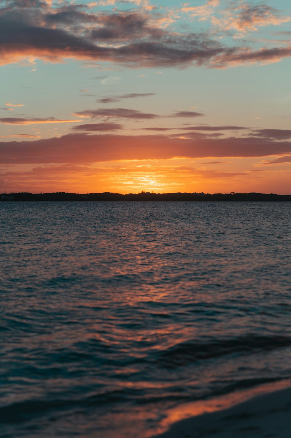 the sun is setting over a body of water