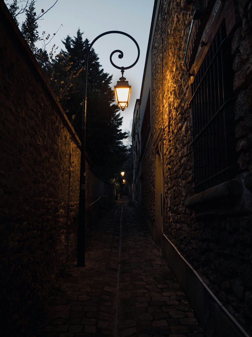 a narrow alley way with a street lamp