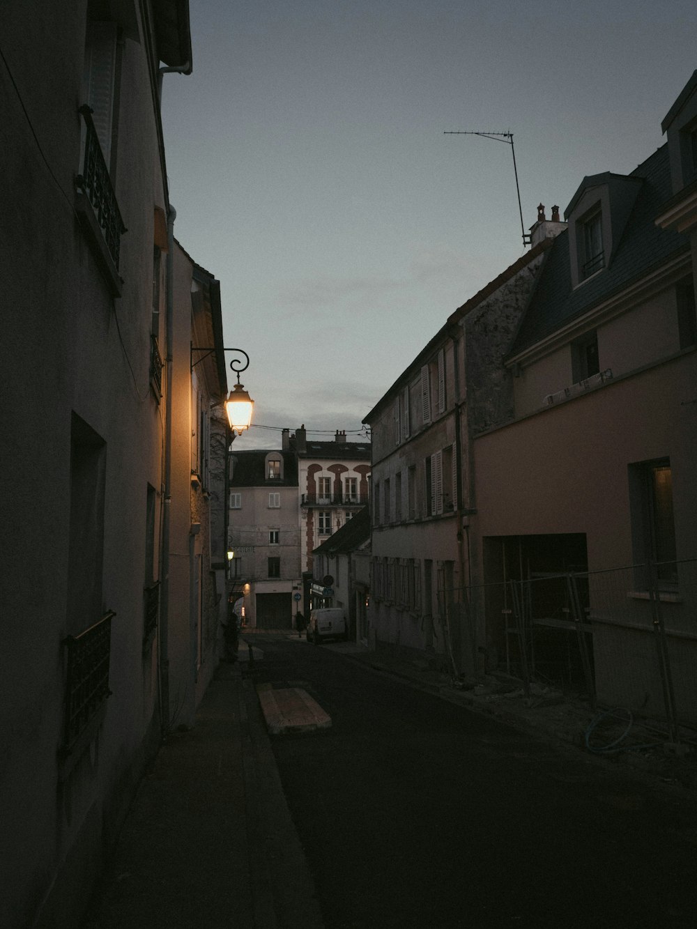 a dark alley way with a street light in the distance