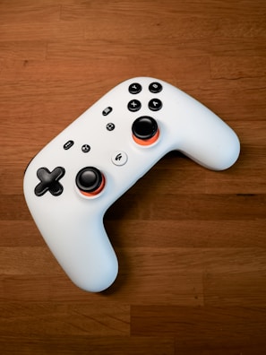 a white controller sitting on top of a wooden floor