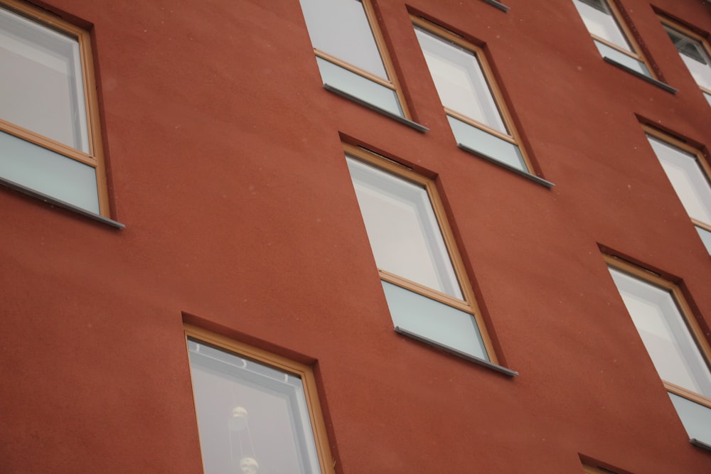 a red building with several windows and a clock