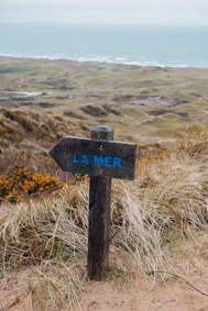a wooden sign pointing in the direction of la mer
