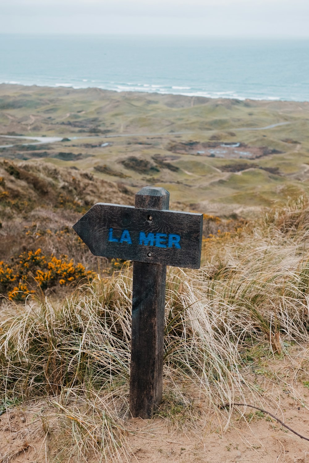 a wooden sign pointing in the direction of la mer