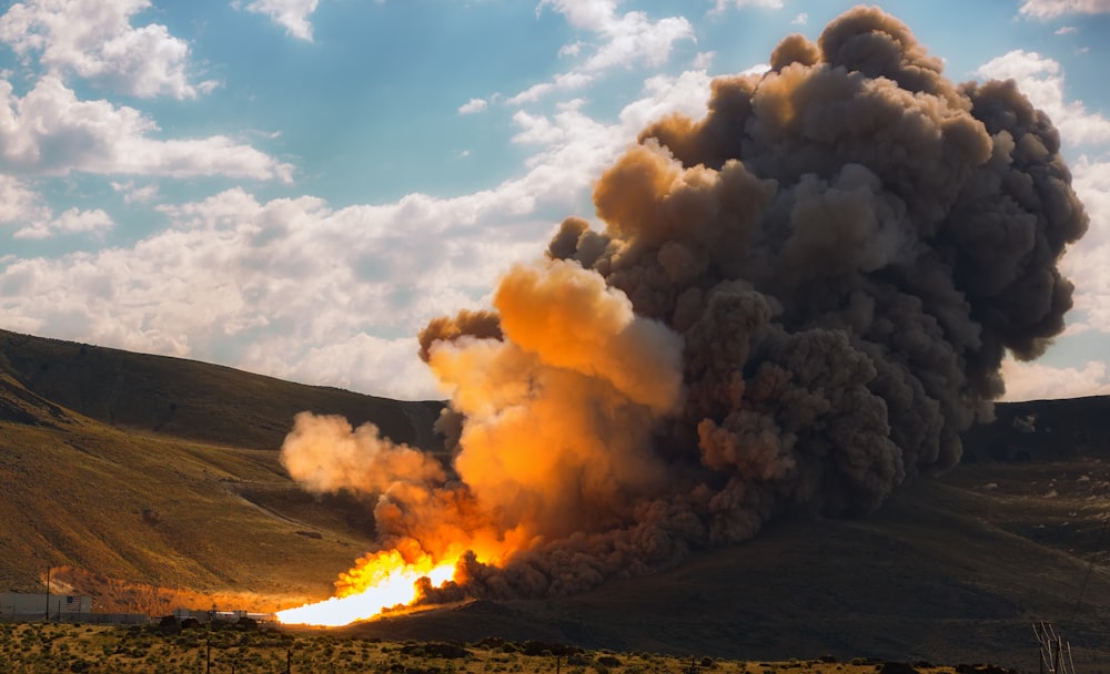 a large plume of smoke billowing out of a mountain