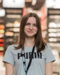 Happy young woman smiling while wearing stylish fashion clothes, representing a satisfied customer of an online fashion store.
