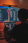 a man sitting in front of two computer monitors