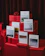 A collection of books with different names are displayed on red wrapped gifts. The books have minimalist covers with nature-themed photographs. The background features a dark red curtain.