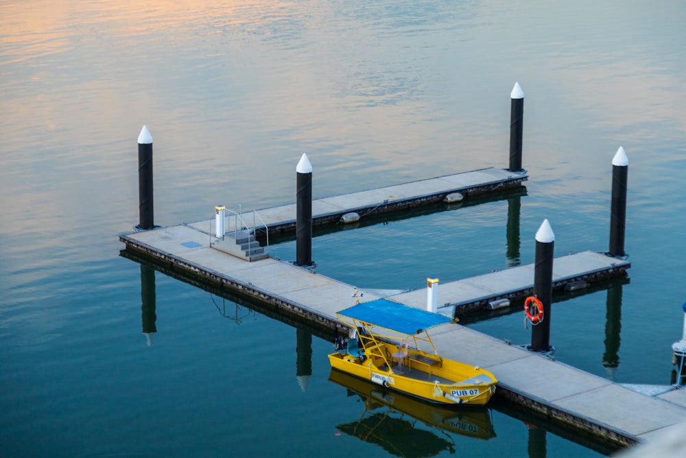 a yellow boat is docked at a pier
