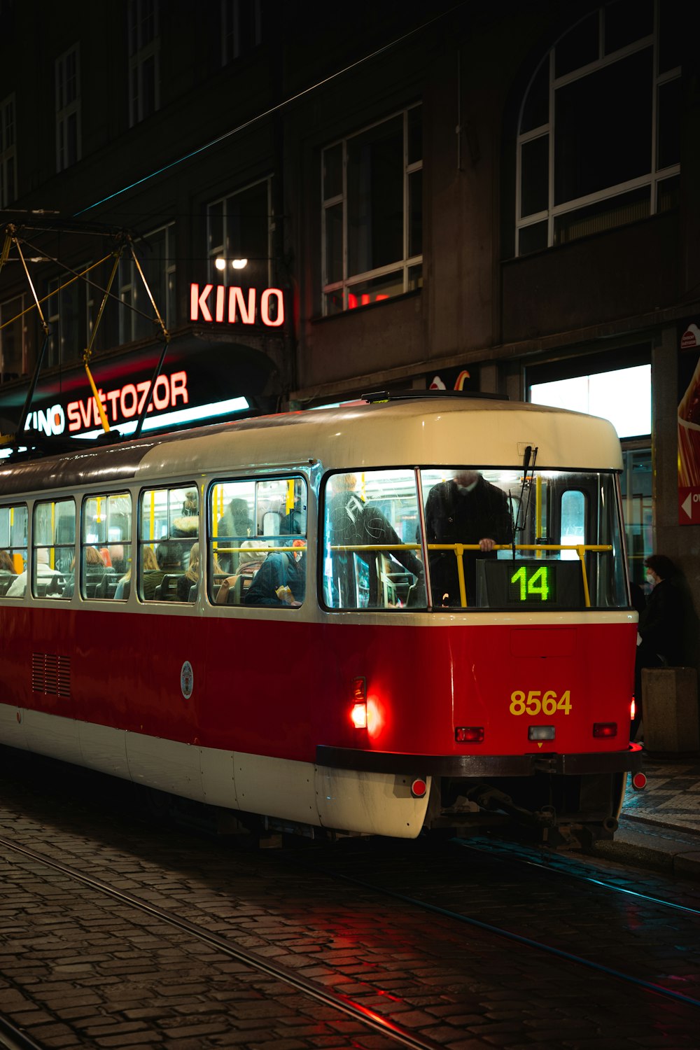 a red and white train traveling down train tracks