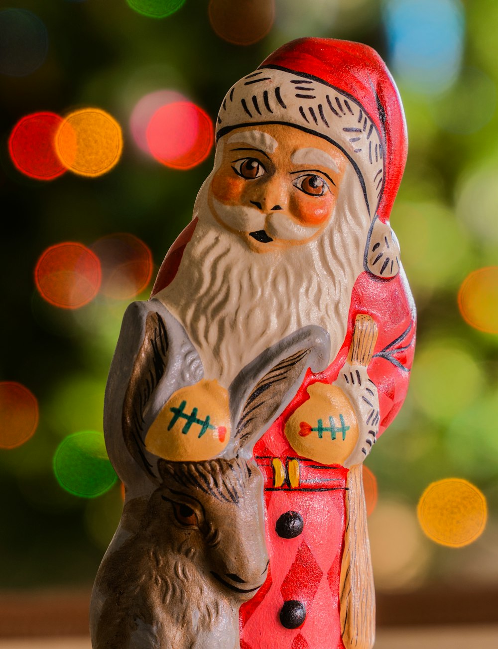 a figurine of a santa holding a deer