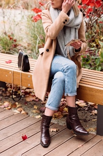 a woman sitting on a wooden bench in a park